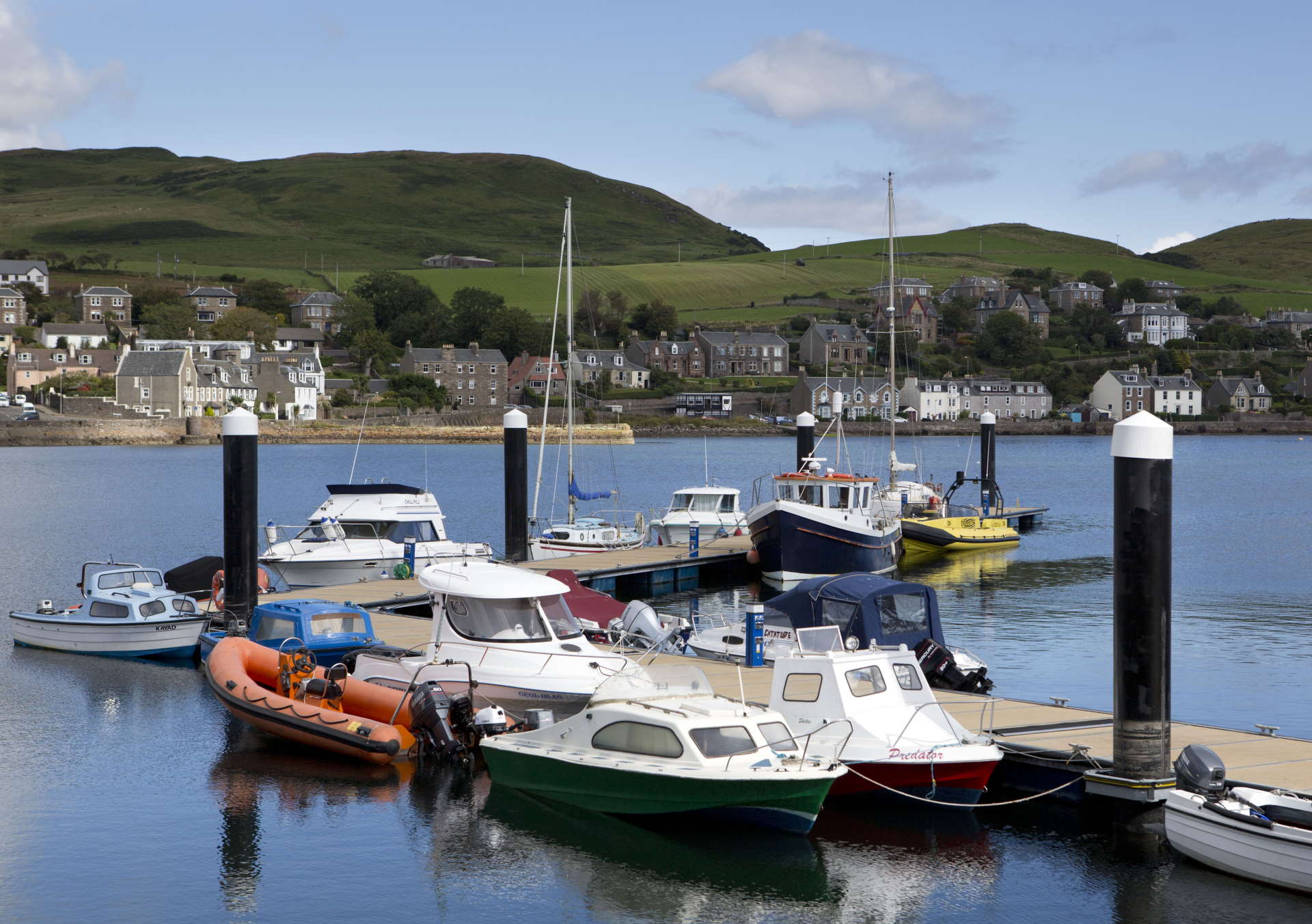 Fishing boats sitting at the harbour amidst blue water in Campbeltown
